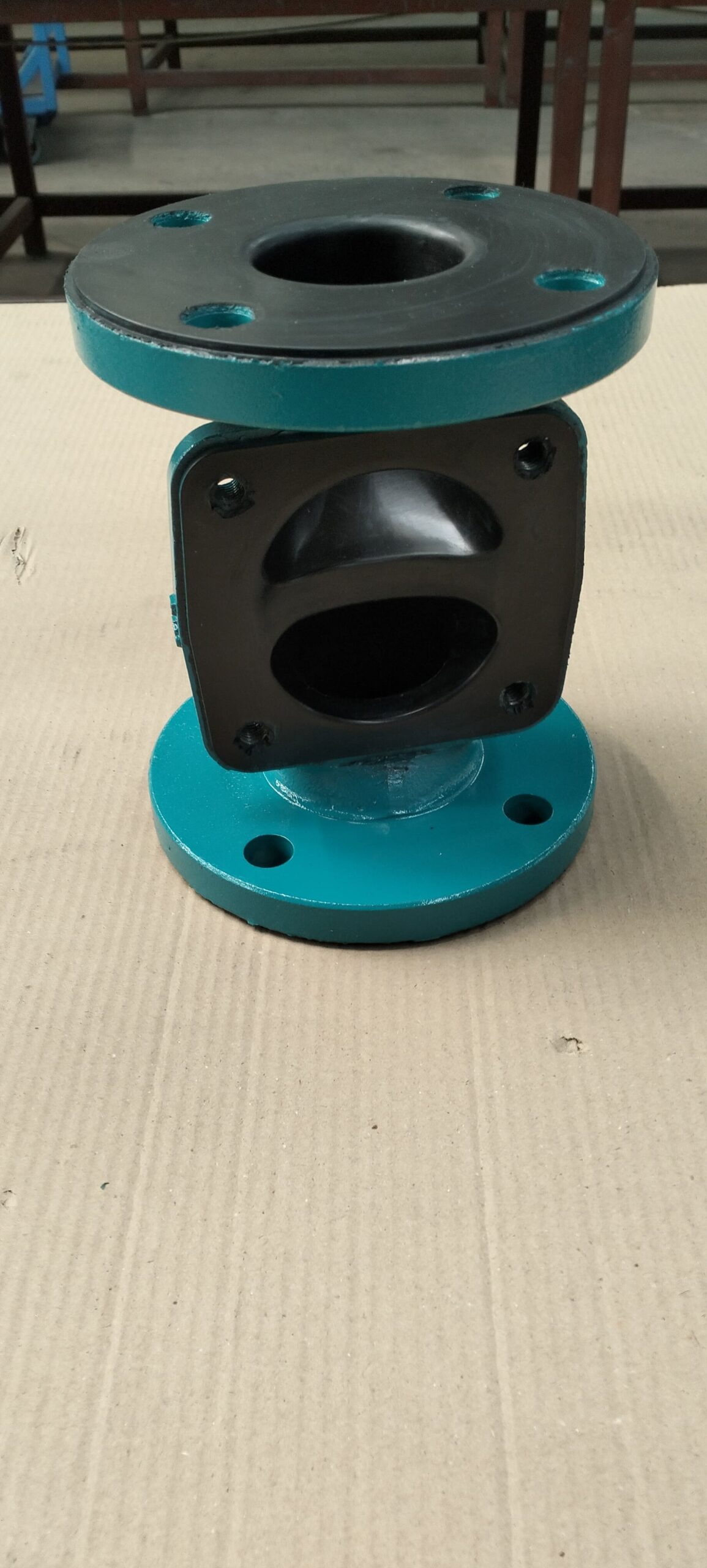 A close-up of a rubber-lined diaphragm valve being inspected.